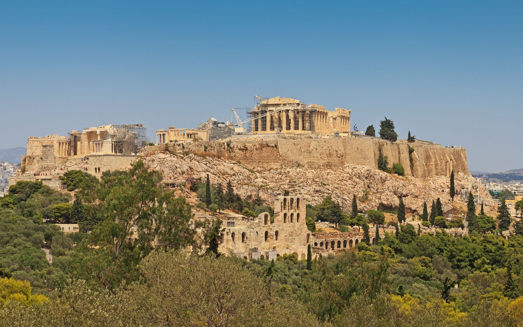 The Acropolis of Athens seen from Philopappos hill, the Parthenon crowning the rock above olive trees